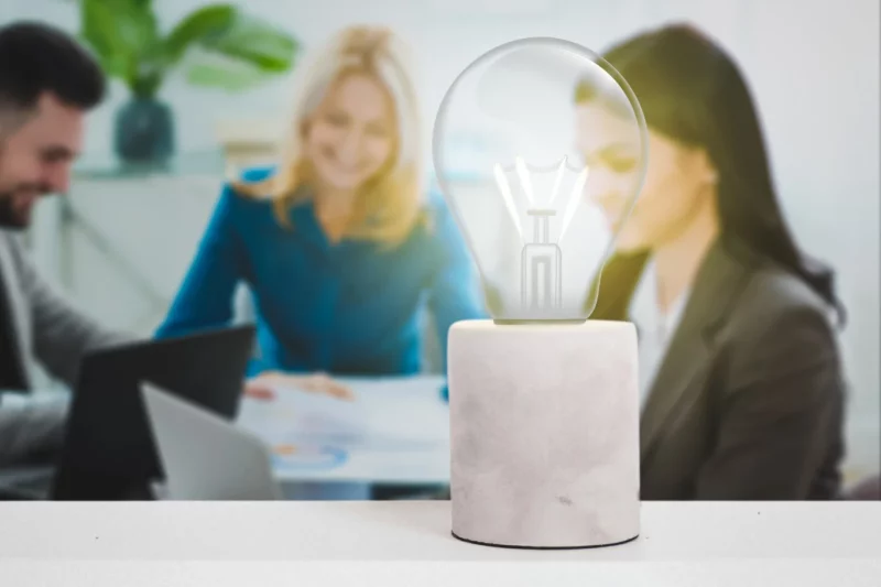 Een lamp die brand met medewerkers van BlueLemon24 in de achtergrond